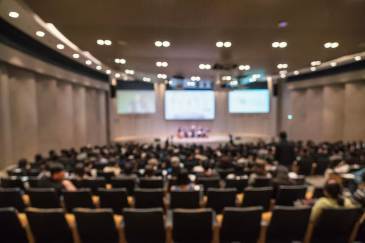 abstract-blurred-photo-conference-hall-seminar-room-with-speakers-stage_41418-2622